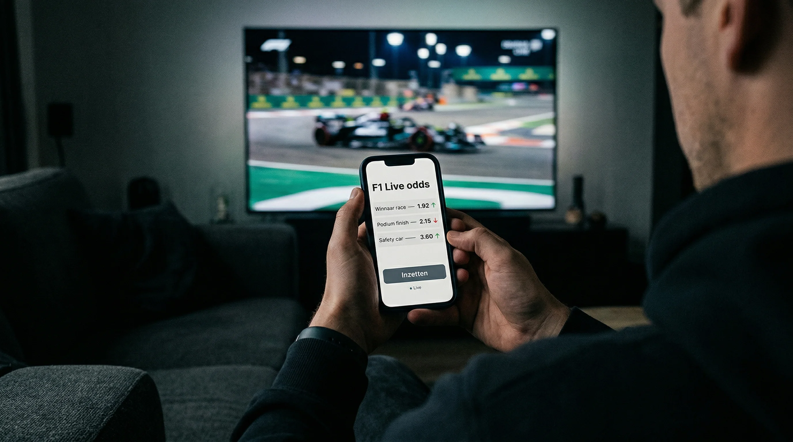 Smartphone met live F1-wedden app naast televisiescherm met race